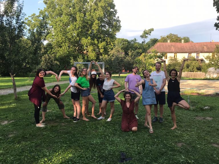 Un gruppo di persone sorridenti in posa per una foto sull'erba verde.