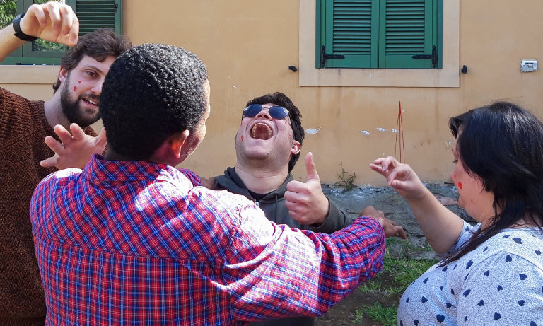 Un gruppo di persone che ride e si diverte insieme in un ambiente festoso.